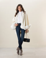 Woman wearing Fur Trimmed Cashmere Cape Petite Length in white. Color: Cervinia Petite