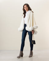 Woman wearing Fur Trimmed Cashmere Cape Petite Length in white. Color: Cervinia Petite