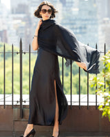 Woman in a silk dress with an Aura Lightweight Cashmere Sequin Wrap in black against a cityscape background