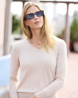 Model wearing Pura Baby Cashmere V-Neck Sweater and sunglasses on a rooftop