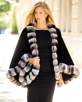 Model with hair flowing in the wind while wearing Imperial Chinchilla Cashmere Cape in black