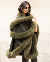 Woman wrapped snuggly in a Cashmere cape coat with real Fur trim in Olive