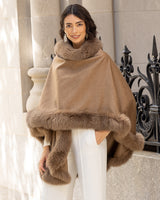Woman wearing a Cervinia fur trim cape in Sable standing outdoors.