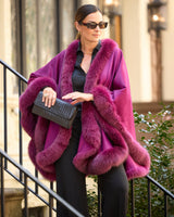 woman holding clutch on a stoop and wearing a berry cervinia and sunglasses