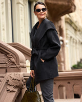 Éloise Double-Face Hooded Wrap Coat in black on model, standing on staircase