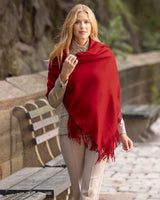 Woman wearing cashmere wrap in deep red outdoors on a stone path