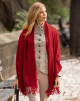 woman walking along a park wearing business blazer and cashmere wrap in deep red