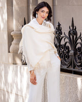 Woman wearing Cashmere water weave wrap with fringe in ivory in an urban setting