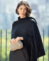 Woman wearing Radiant Cashmere Sequin Wrap in black holding a handbag