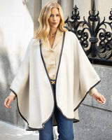 Woman wearing a Reversible Cashmere Cape with Leather trim in Oat/Grey in an urban setting