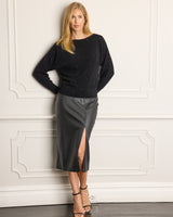 Model wearing Stella Sequin Boat Neck Sweater in black standing against a wall