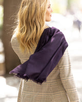 Woman wearing a Lightweight cashmere wrap in Dark Currant and plaid coat outdoors