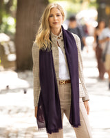 Woman wearing a Lightweight cashmere wrap in Dark Currant and casual outfit on a city street