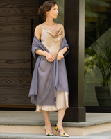 woman wearing silk dress wrapped in st tropez lightweight cashmere wrap in mauve purple