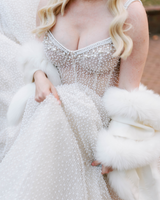 Close up of bride wearing cashmere capri fur trimmed shawl in white