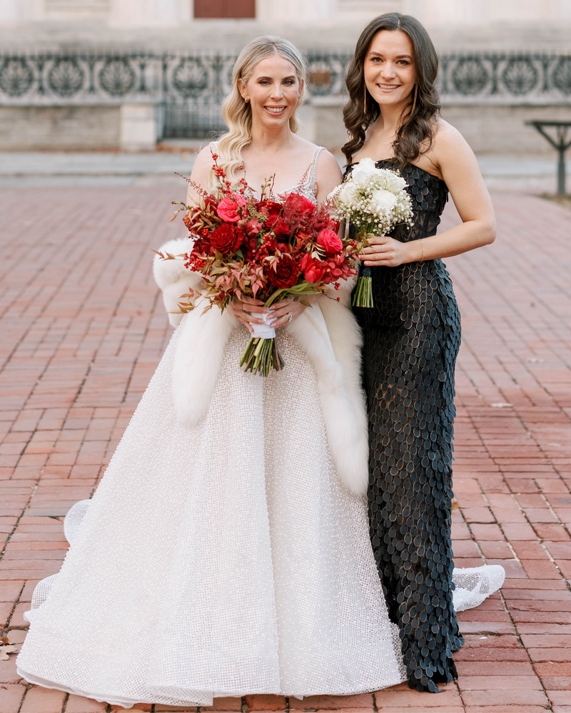 photo of bride and bridesmaid; bride wearing white cashmere fur trimmed capri shawl