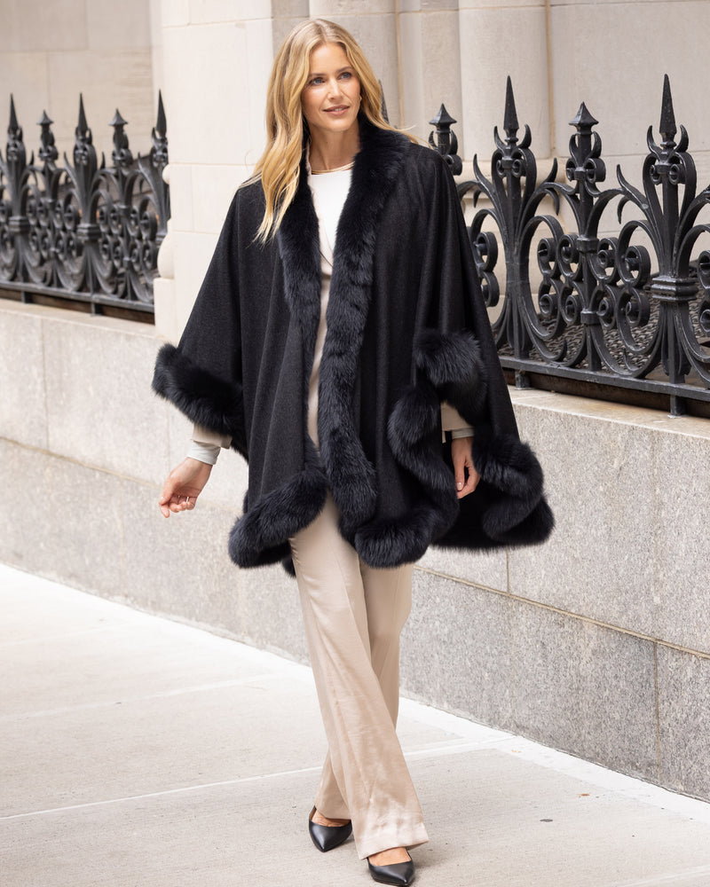 Woman wearing a Fur Trimmed Cape in Charcoal in an urban setting.
