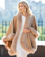 Woman wearing a Fur Trimmed Cashmere Cape in Camel cityscape background