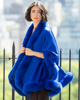 Woman wearing a Cervinia Cashmere Cape with real fur trim in Electric Blue 