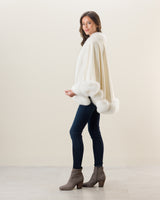 Woman wearing Fur Trimmed Cashmere Cape Petite Length in white. Color: Cervinia Petite