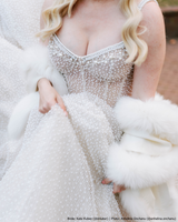 Close up of bride wearing cashmere capri fur trimmed shawl in white