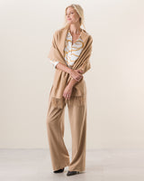 Woman wearing Cashmere water weave wrap with fringe in camel 