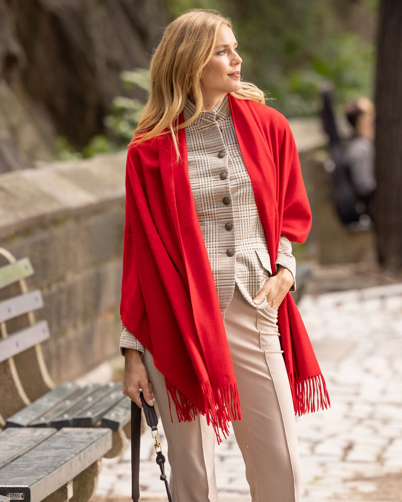Woman wearing Cashmere water weave wrap with fringe in red and work outfit in an outdoor setting
