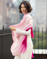 Woman wearing a Lightweight Cashmere Wrap in pink ombre with a blurred background