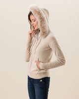 Woman wearing Cashmere zip sweater with fur trimmed hood in Oatmeal