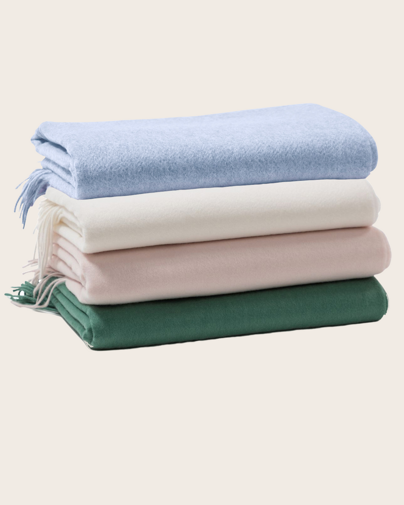 Stack of three trentino throws in pale colors