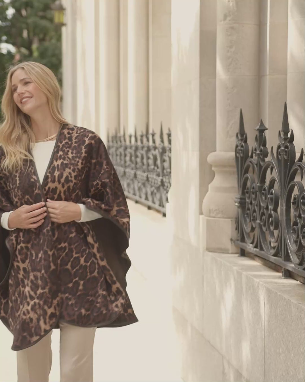 woman walking wearing Roma Wild Reversible Cashmere Cape in Leopard Camel/Brown