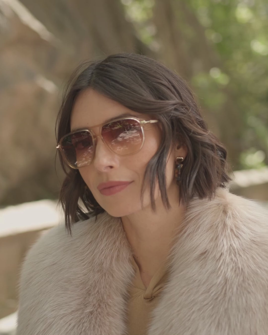woman walking Parkside wearing a 3/4 length cashmere coat with fur collar in Blonde