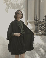 Woman waling and wearing cashmere Knitted Cape with ruffles in Black