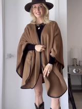 alpaca wool leather trimmed cape in camel color worn by stylist samantha brown with leather shorts and boots