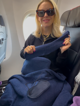 stylist Samantha Brown showing cashmere travel set in denim on airplane; holding cashmere socks