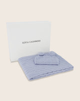 Cable knit baby blanket and pom-pom hat set in soft blue in gift box