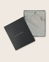 Cable knit baby blanket and pom-pom hat set in light grey, neatly packed in gift box