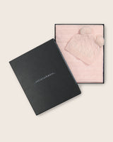Cable knit baby blanket and pom-pom hat set in soft pink packed neatly in open Sofia Cashmere gift box
