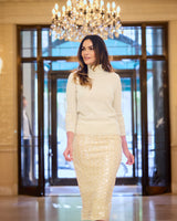 model wearing Pura Baby Cashmere Turtleneck Sweater in ivory with a chandelier in the background