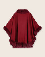 back view of burgundy cape with fur trim on a clean background