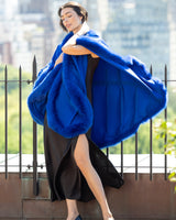 Woman standing on rooftop a Cervinia Cashmere Cape with real fur trim in Electric Blue 