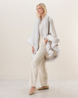 Woman wearing Fur Trimmed cashmere Cape in Glacier white