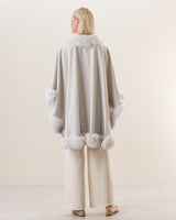 Woman Wearing Fur Trimmed cashmere Cape in Glacier white, back view