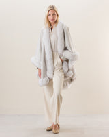 Woman wearing Fur Trimmed cashmere Cape in Glacier white
