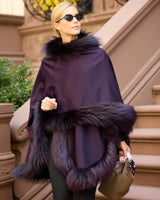 Woman wearing currant multi silver fur trimmed cervinia standing on a stoop holding a purse