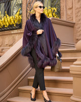 Woman wearing currant multi silver fur trimmed cervinia and sunglasses standing on a stoop holding a purse