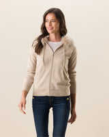 Woman wearing Cashmere zip sweater with fur trimmed hood in Oatmeal