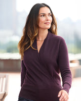 Model walking on a rooftop wearing Élan Faux Wrap Cashmere Sweater in fig