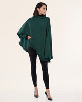 model wearing Volant cashmere ruffled cape in green with leggings and heels
