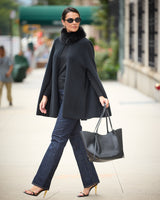 Model  on the street wearing Arden Cashmere Cape in black with sunglasses and a handbag